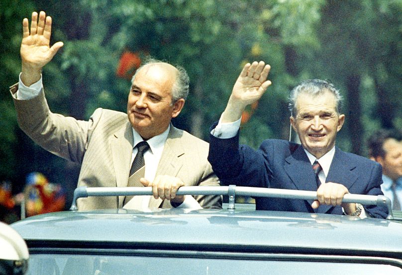 Le dirigeant soviétique Mikhaïl Gorbatchev et Nicolae Ceaușescu saluent la foule alors qu'ils traversent le centre-ville de Bucarest le 25 mai 1987