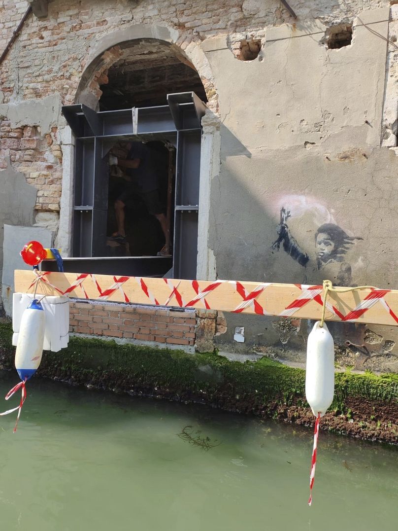 Banksy's work 'The Migrant Child' has been removed from the facade of Palazzo San Pantalon in Venice for restoration