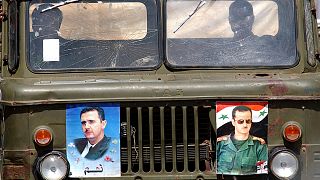 Syrian soldiers drive an army truck with posters of Syrian President Bashar al-Assad at the Masnaa border crossing, 8 April 2005