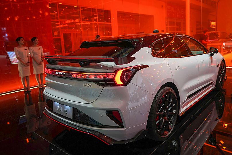 Funcionários junto a um automóvel Zeekr 001FR durante a abertura do Salão Automóvel da China em Pequim, China, quinta-feira, 25 de abril de 2024. 