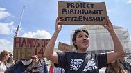  Hannah Liu, 26, of Washington, holds up a sign in support of birthright citizenship, May 15, 2025, outside of the Supreme Court in Washington. 