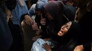 Майсара Адван (слева) скорбит, держа в руках тело своего 11-летнего сына Каиса, погибшего в результате израильского авиаудара по школе в Газе, которая использовалась в качестве убежища, во время