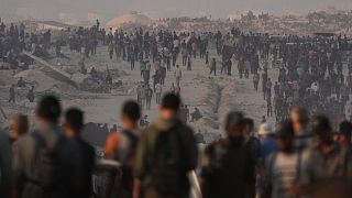 Palestinians walk along a road toward an area in the northern Gaza Strip where trucks are entering with humanitarian aid, in Gaza City, 26 July 2025