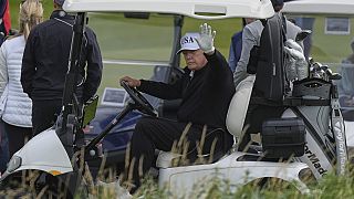 President Donald Trump waves to reporters as he sits in his golf cart at the Trump Turnberry golf course in Turnberry, Scotland, Saturday, July 26, 2025.
