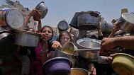 Palestinians struggle to get donated food at a community kitchen, in Gaza City, northern Gaza Strip, Saturday, July 26, 2025. (AP Photo/Abdel Kareem Hana)