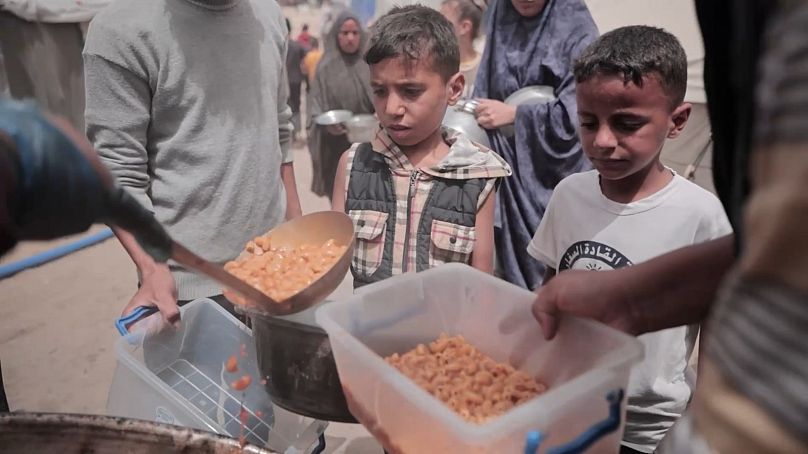 أطفال يحصلون على الطعام من أحد المطابخ الخيرية