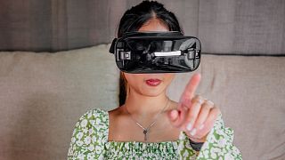 A woman wears a virtual reality headset.