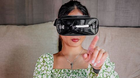 A woman wears a virtual reality headset.