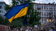 A man waves a flag during a protest against a law targeting anti-corruption institutions in central Kyiv, Ukraine, Tuesday, July 22, 2025.