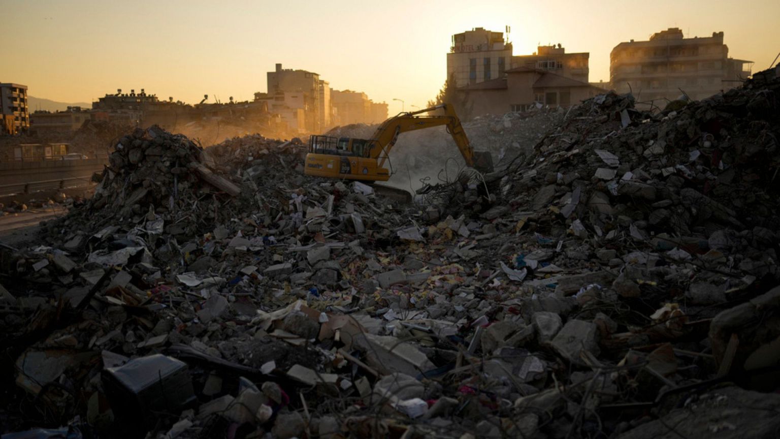 FILE - An excavator digs in the rubble of destroyed buildings in Iskenderun city, southern Turkey, 14 Feb 2023.