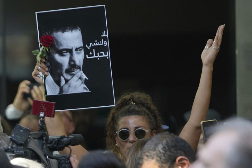 تحمل إحدى المشيّعات صورة زياد الرحباني، المؤلف والكاتب المسرحي وعازف البيانو اللبناني المبدع  خلال مشاركتها في جنازته في بيروت، لبنان، يوم الاثنين 28 تموز/يوليو 2025.