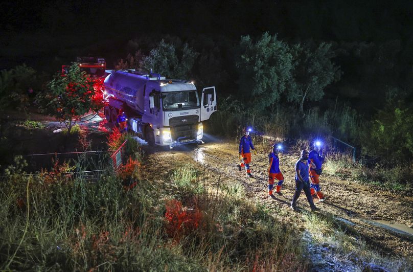 Bombeiros trabalham durante a noite para extinguir um incêndio florestal em Bursa, na Turquia, na madrugada de domingo, 27 de julho de 2025.