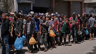 ARCHIVO: Palestinos hacen cola para la distribución de alimentos en Deir al-Balah, Franja de Gaza, viernes 30 de mayo de 2025. 