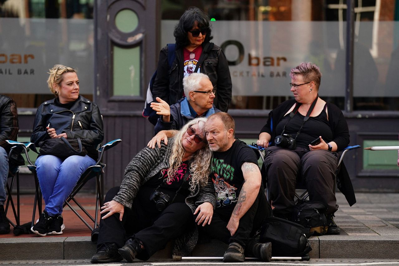 Fans gather near the Black Sabbath Bridge bench on Broad Street ahead of the funeral procession