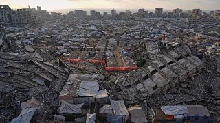 A tent camp for displaced Palestinians stretches among the ruins of buildings destroyed by Israeli bombardments in west of Gaza City, 21 June 2025