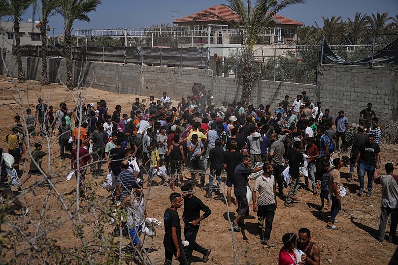 Palestinians rush to collect humanitarian aid airdropped into Zawaida in central Gaza Strip, 30 July, 2025