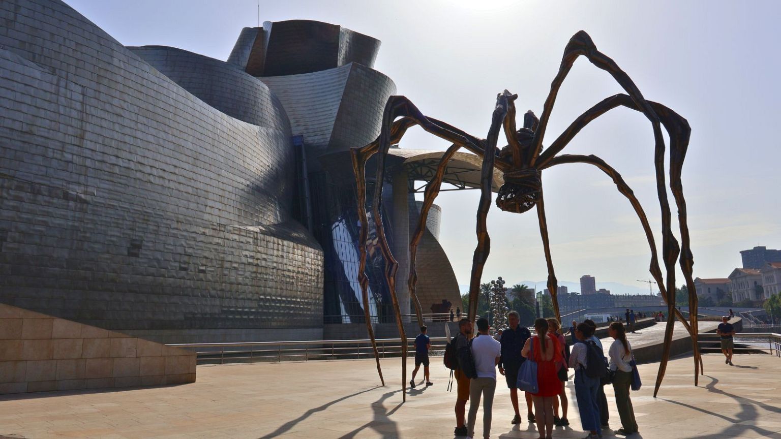 Tourists gather beneath Louise Bourgeois’ Maman sculpture outside the Guggenheim Museum during a heatwave, 30 June 2025.