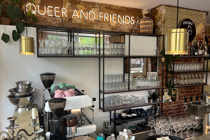 Interior view of the 'Das Hoven' cafe with a neon sign reading 'Queer And Friends' in Berlin, Germany, 31 July 2025.