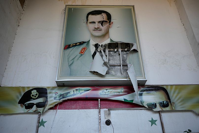 Um cartaz rasgado do ex-presidente Bashar al-Assad num centro de detenção em Damasco, 14 de dezembro de 2024.