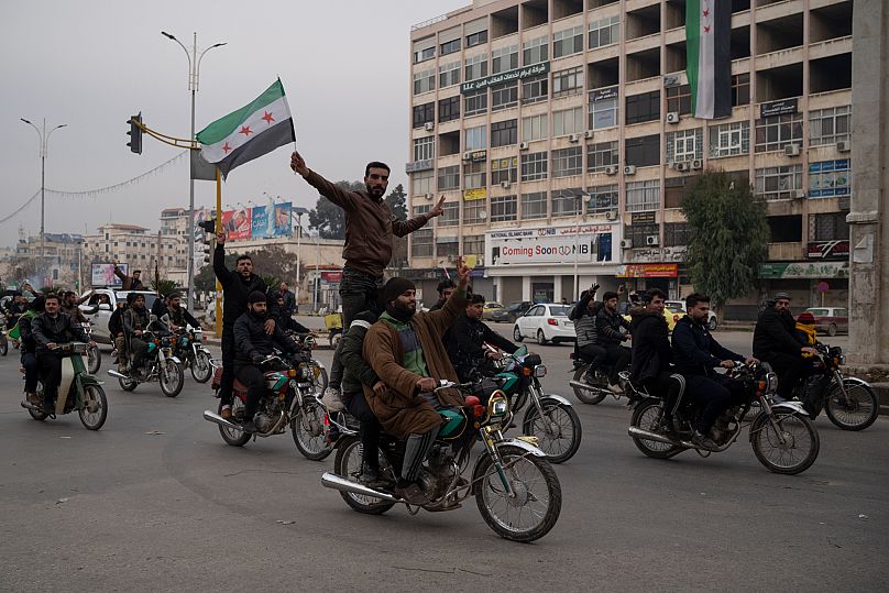 Pessoas comemoram a queda do presidente sírio deposto Bashar al-Assad nma rua em Hama, em 4 de janeiro de 2025.