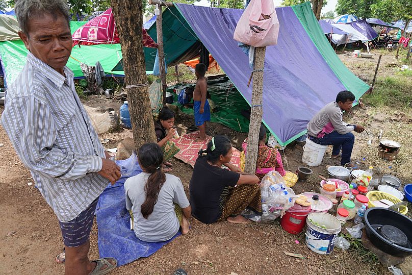 Cambodian villagers cook their lunch under a tent at a resettlement camp in Wat Phnom Kamboar, 29 July, 2025