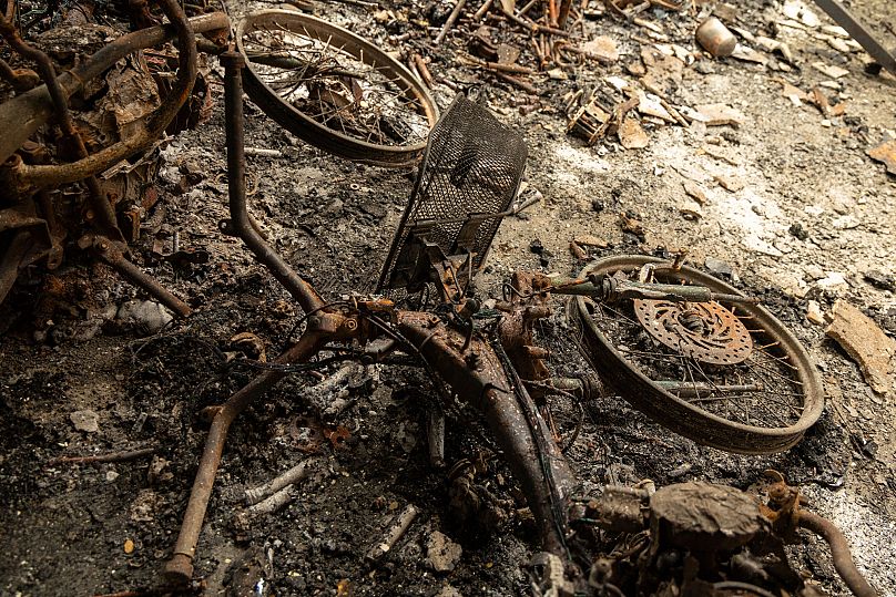 Torched motor cycles lie in ruins in a bombed building in O'Smach in Cambodia, 30 July, 2025 