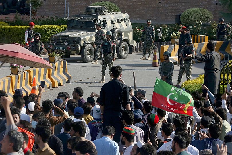 Paramilitary soldiers from Frontier Corps stand guard outside their headquarters where supporters of Imran Khan protest against his arrest in Peshawar, 9 May, 2023