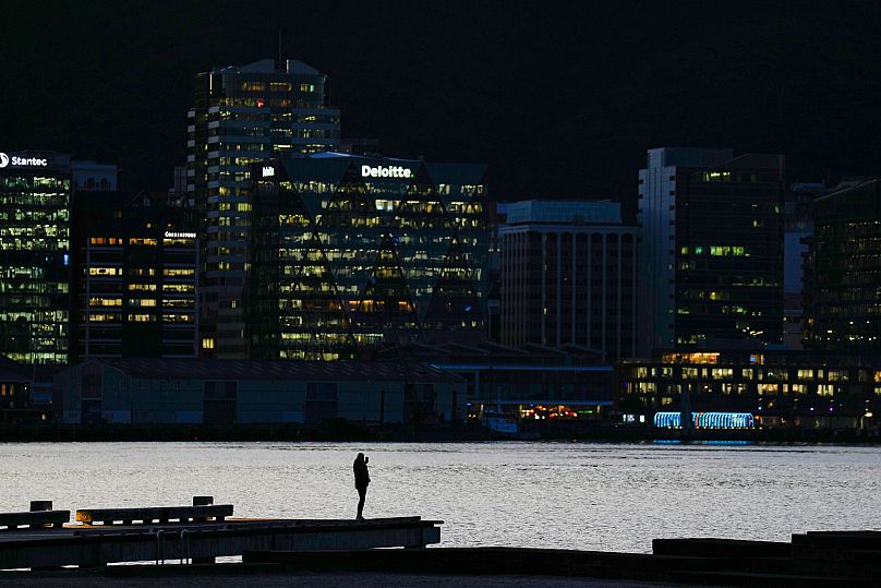 A person stands by the Wellington waterfront, 9 August, 2023