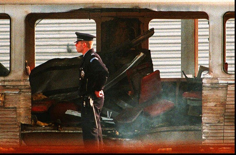 شرطي قرب موقع انفجار قنبلة في قطار بمحطة متحف أورسي عام 1995.
