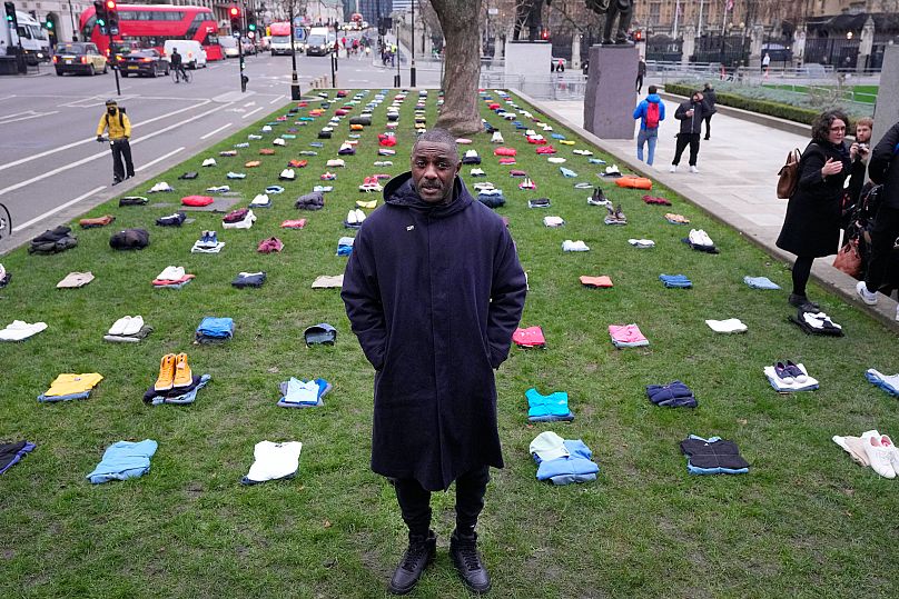 O ator britânico Idris Elba na Praça do Parlamento com roupas que representam o custo humano dos crimes com faca no Reino Unido, em Londres, em 8 de janeiro de 2024
