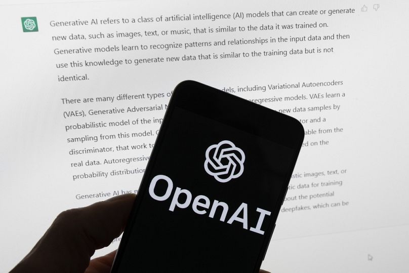 شعار OpenAI يظهر على هاتف محمول أمام شاشة، في بوسطن، 21 مارس 2023.