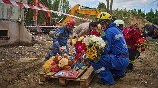 Rescuers lay toys and flowers on the site of Russia's Thursday night missile strike that hit a residential house in Kyiv, 1 August, 2025