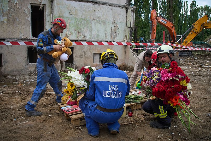 Los equipos de rescate depositan juguetes y flores en el lugar donde el jueves por la noche Rusia lanzó un misil contra una casa de varios pisos en la que murieron 31 civiles