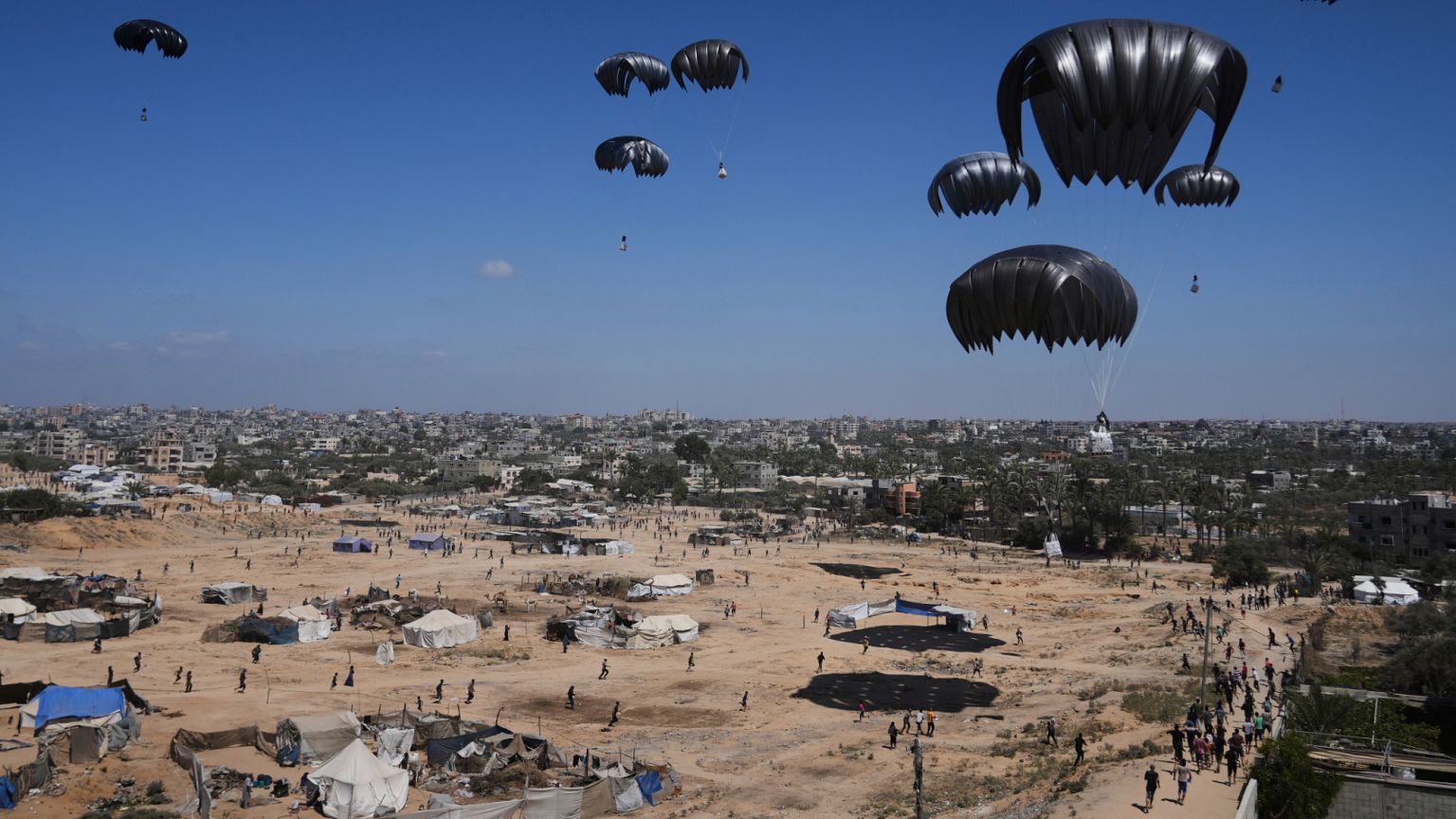 Palestinos se apresuran a recoger la ayuda humanitaria lanzada desde el aire en Zawaida, en el centro de la Franja de Gaza, el jueves 31 de julio de 2025. 