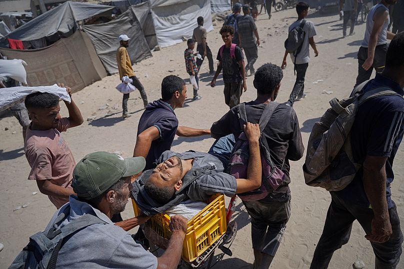 Um palestiniano é transportado depois de ter sido ferido quando tentava chegar aos camiões que transportavam ajuda humanitária a caminho da cidade de Gaza