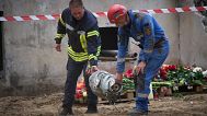 FILE: Searchers carry a fragment of the Russian missile that hit a multistory residential house on Thursday evening, in Kyiv, 1 August 2025