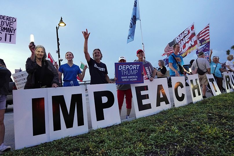 Protesters display "Impeach Trump" signs during a rally near Mar-a-Lago in Palm Beach, as part of the "Good Trouble Lives On" national day of action - 17 July 2025