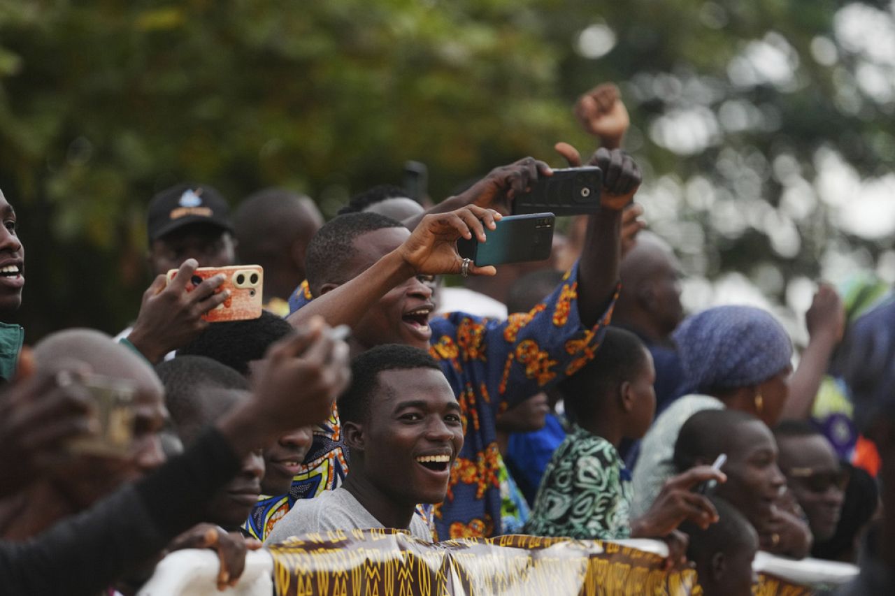 Onlookers film on mobile phones as people dressed in costumes perform during the mask festival in Porto-Novo, Benin.
