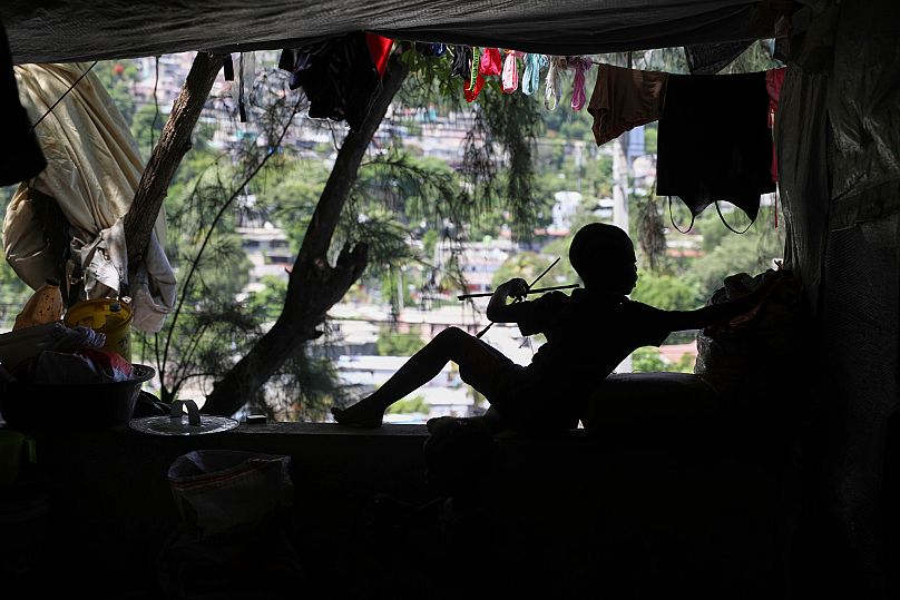 A child builds a kite at a shelter for families displaced by gang violence in Port-au-Prince, 5 June, 2025