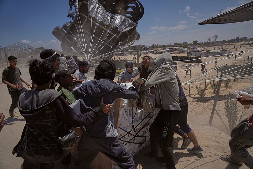 Palestinians rush to collect humanitarian aid airdropped by parachutes into Deir al-Balah, 5 August, 2025