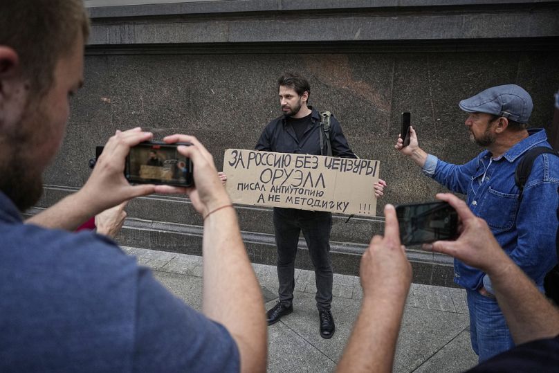 Bir aktivist Rus Parlamentosu'nun alt kanadı Duma'nın önünde, “Sansürsüz bir Rusya için. Orwell bir distopya yazdı, kullanım kılavuzu değil” dövizini taşırken, 22 Temmuz 2025 