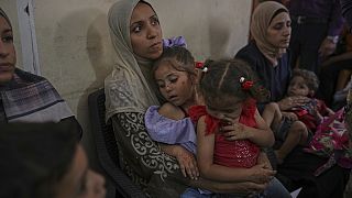 نساء فلسطينيات ينتظرن مع أطفالهن المرضى للحصول على الرعاية الطبية في عيادة مكتظة في مدينة غزة، الأربعاء 28 مايو/أيار 2025