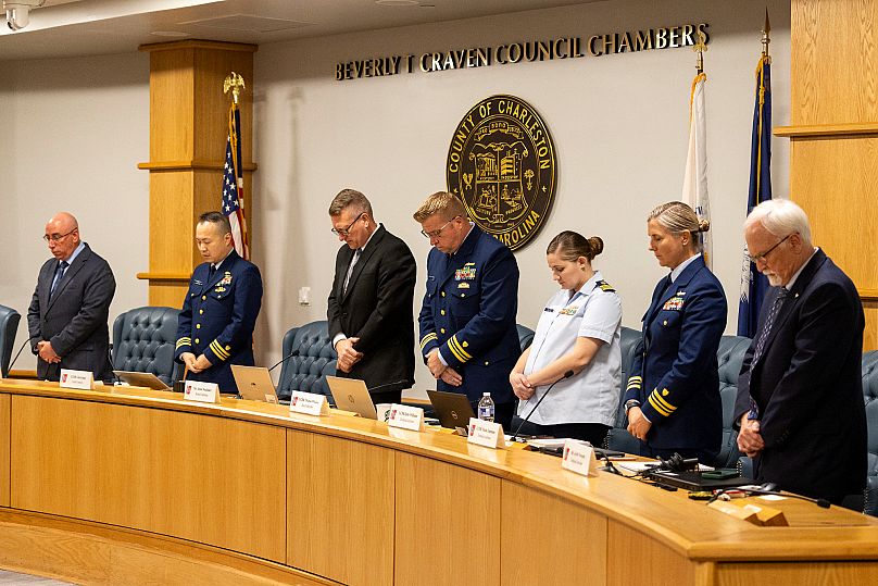 Members of the investigative board stand for a moment of silence at the conclusion of the Coast Guard investigatory hearing on the causes of the Titan implosion, 27 September,