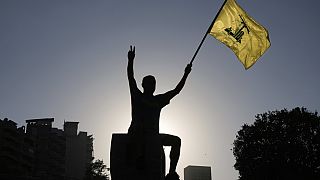 فایل: یکی از حامیان حزب الله روز شنبه ۲۶ ژوئیه ۲۰۲۵ در بیروت لبنان پرچم حزب الله را برافراشته است.