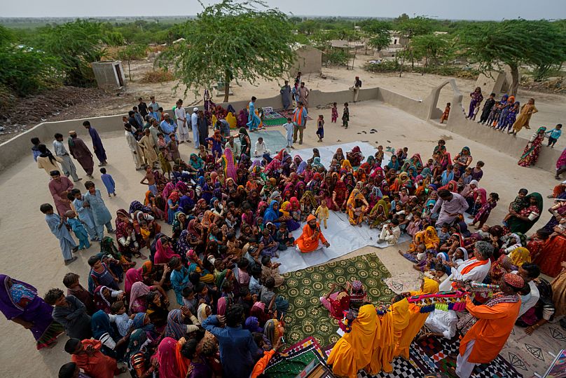 Villagers watch a performance of a Pakistani folk musician Sham Bhai at a village in Umerkot, a district of Pakistan's southeastern Sindh province, 17 July 2025.