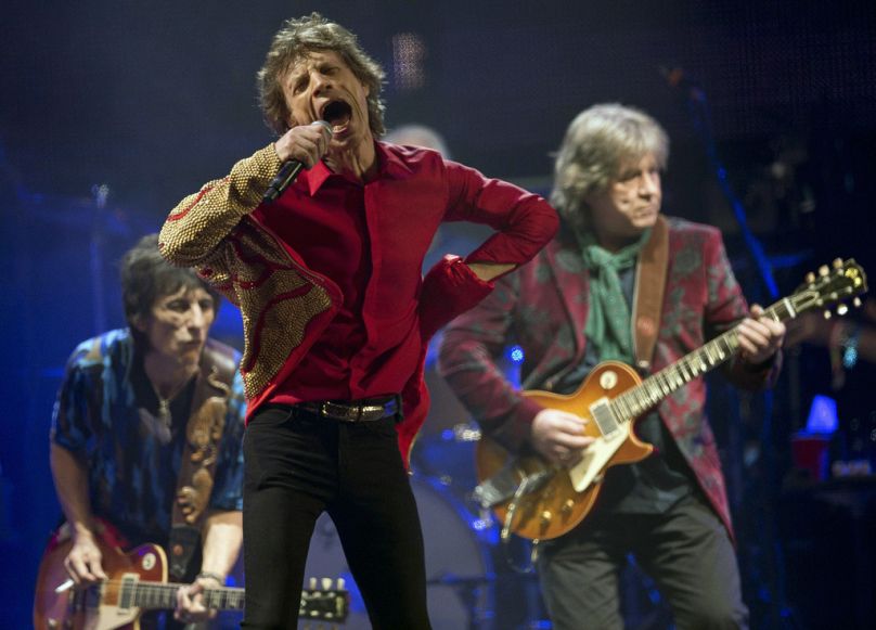 Mick Jagger, center, Ronnie Wood, left, and Mick Taylor, of British rock band The Rolling Stones, perform on the Pyramid main stage at Glastonbury in 2013.