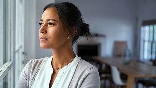 A woman looks out a window.