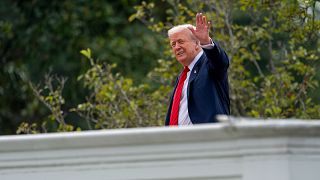 FILE: US President Donald Trump waves to reporters from the roof of the White House, 5 August 2025