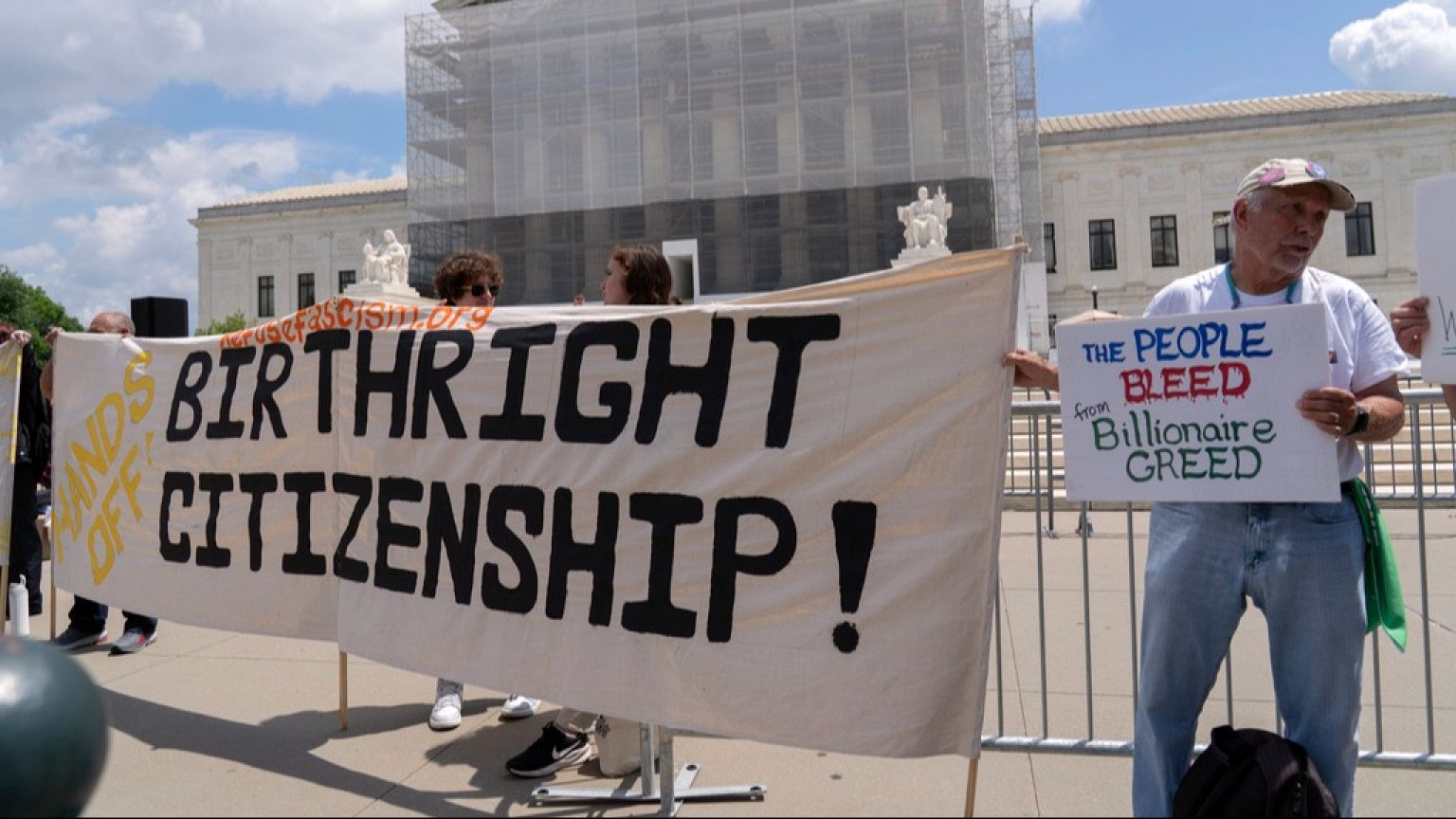 FILE - Demonstrators holds up a banner during a citizenship rally outside of the Supreme Court in Washington, May 15, 2025