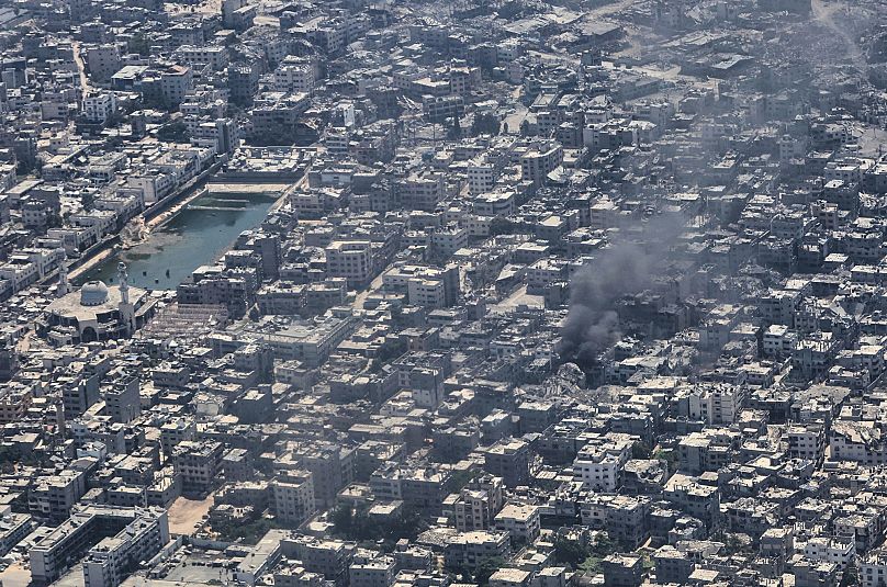 From aboard a Jordanian Air Force C-130, smoke is seen rising from Gaza City during an aid airdrop, 7 August 2025.